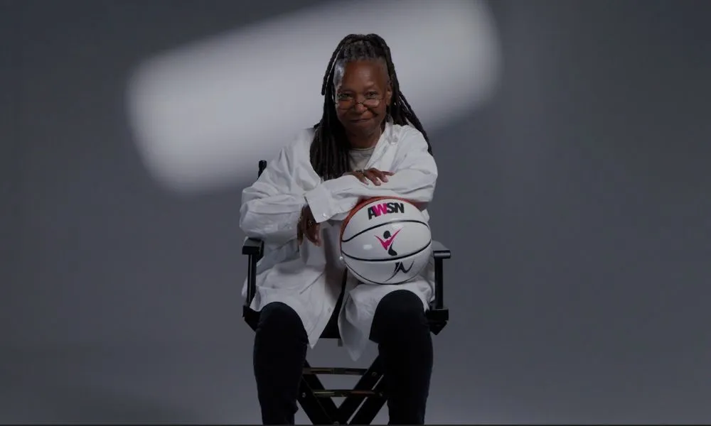Whoopi Goldberg est assise avec un ballon aux couleurs du réseau AWSN