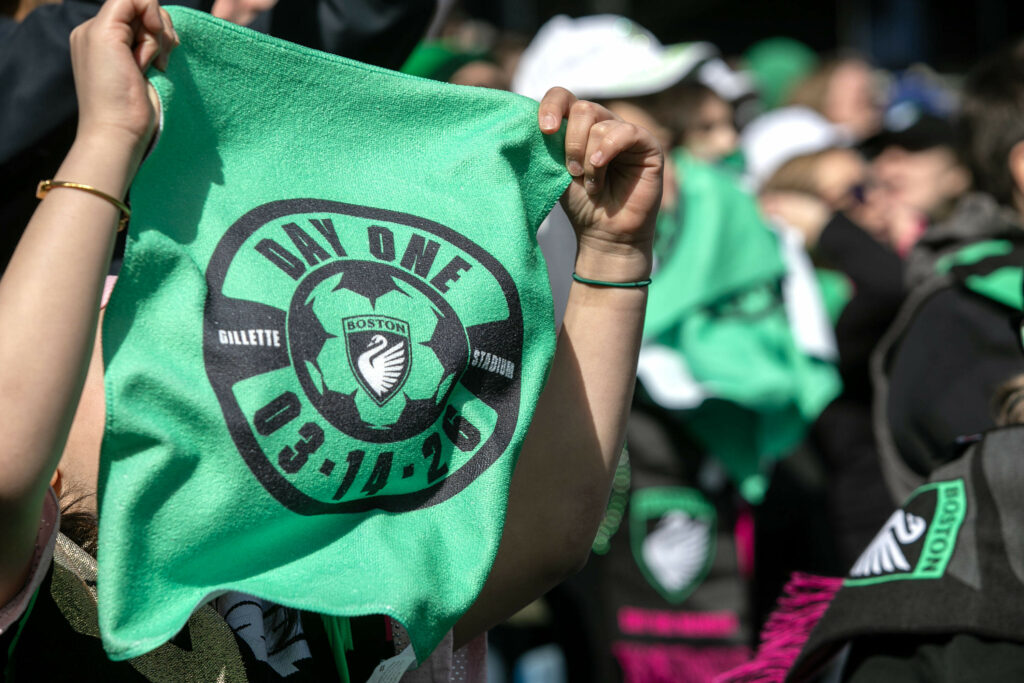 Un supporter du Boston Legact montre une serviette commémorative du match inaugural du clyub en NWSL